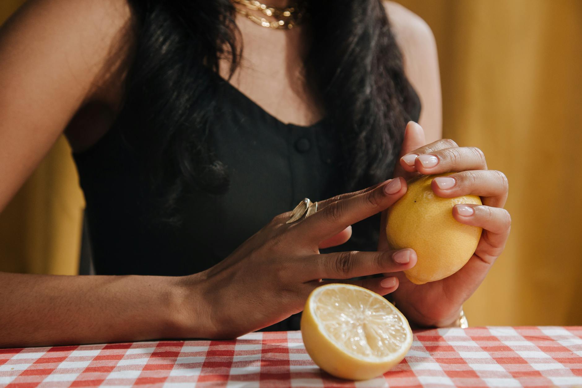 A person holding a fresh lemon, symbolizing refreshment and renewed pleasure.