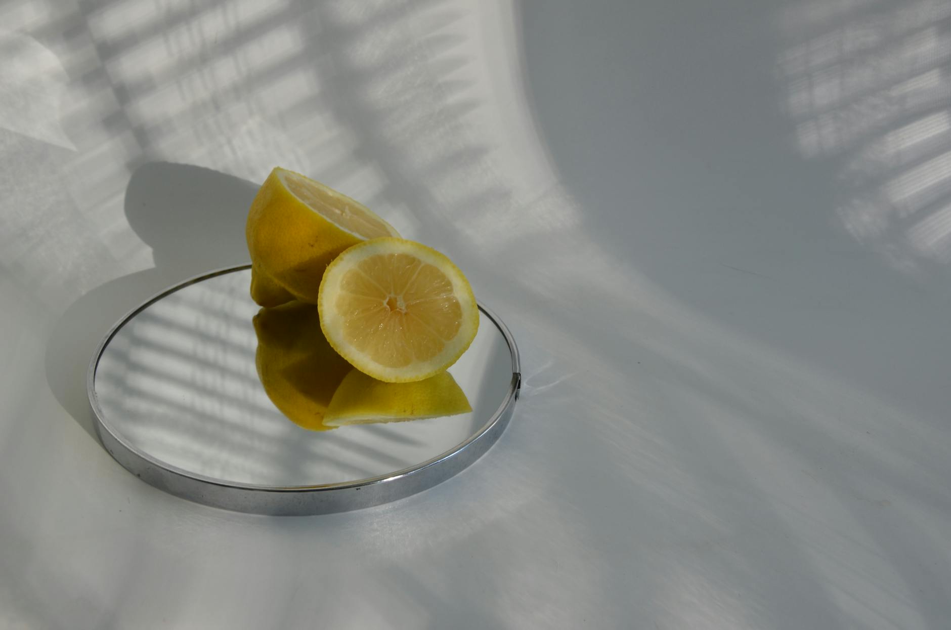 A hand holding a blue vibrator above a decorative glass bowl