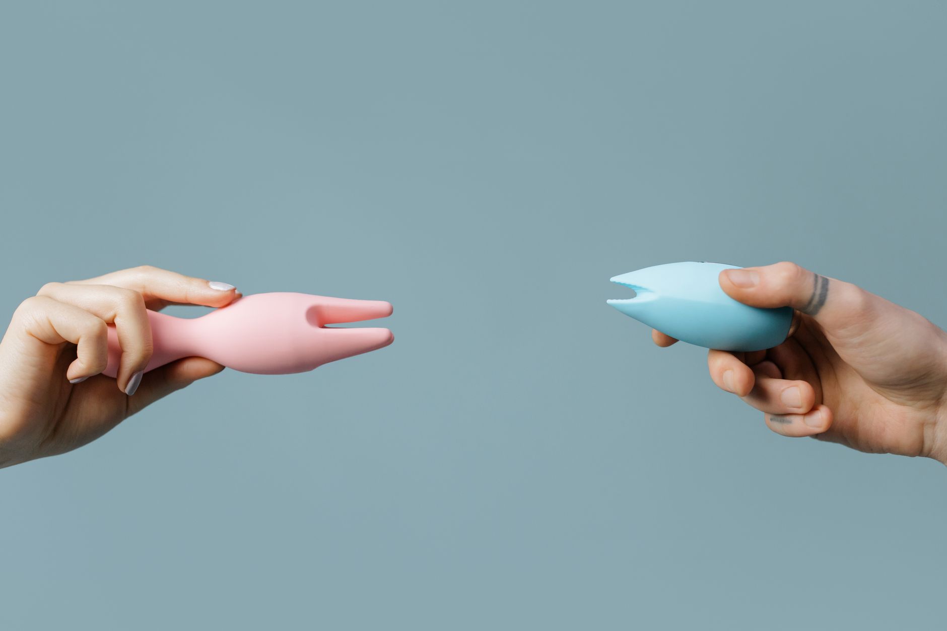 A hand holding a blue silicone vibrator against a purple background, symbolizing solo pleasure and sensual exploration.
