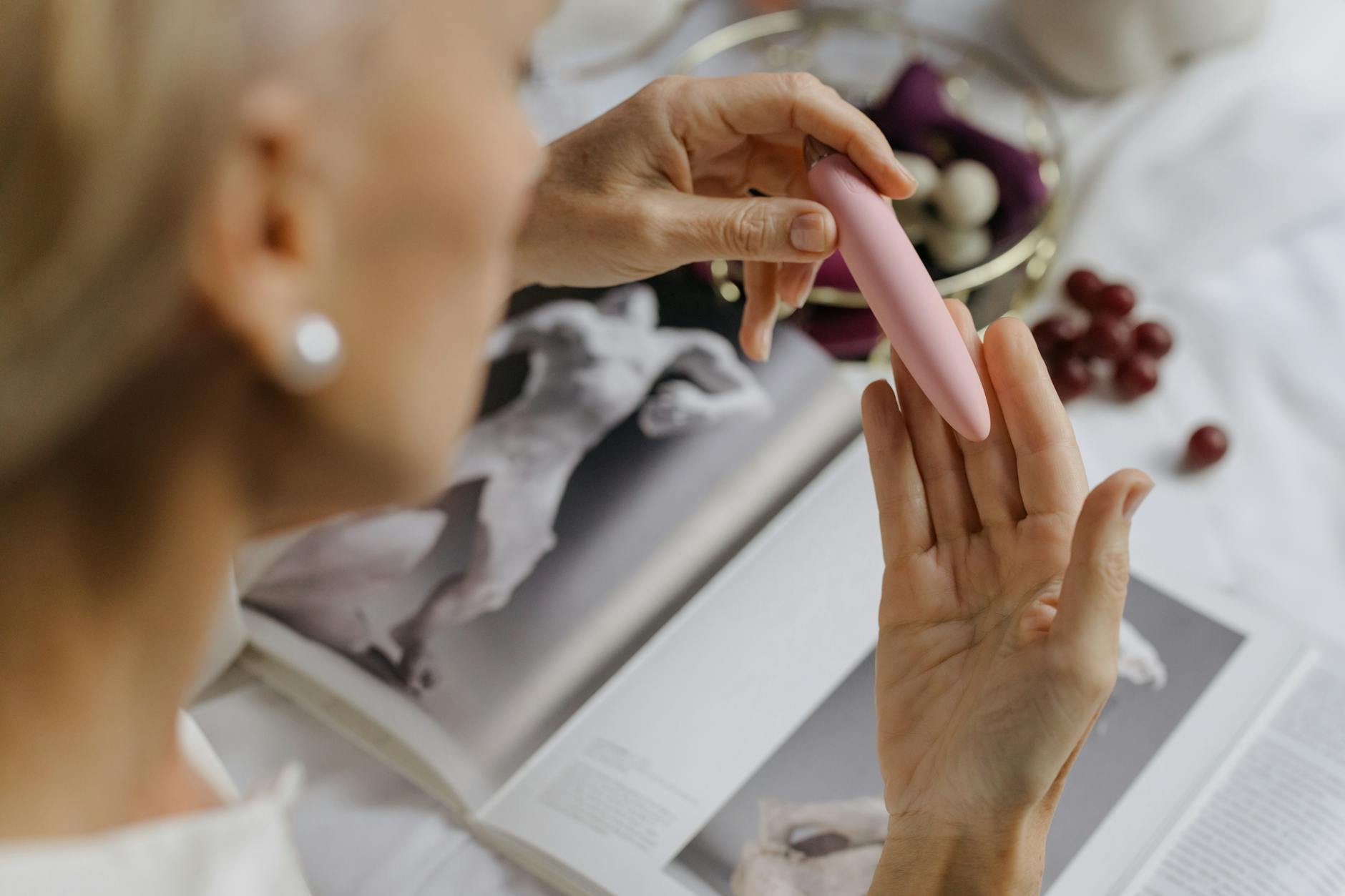 Woman holding a vibrator with intimate, personal expression in a private moment