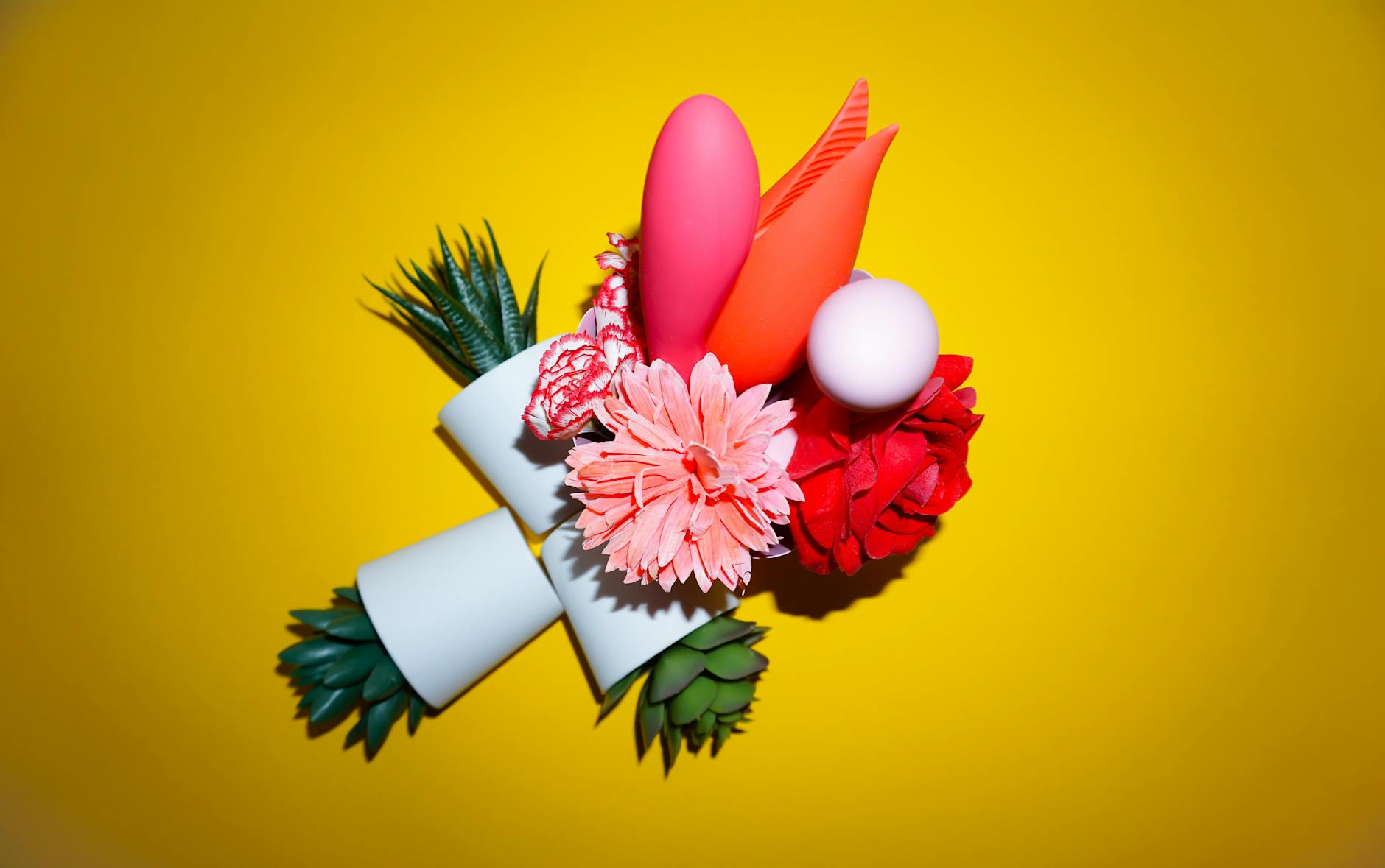 Person holding colorful clitoral vibrators against a purple background, representing lemon vibrators and sexual wellness tools